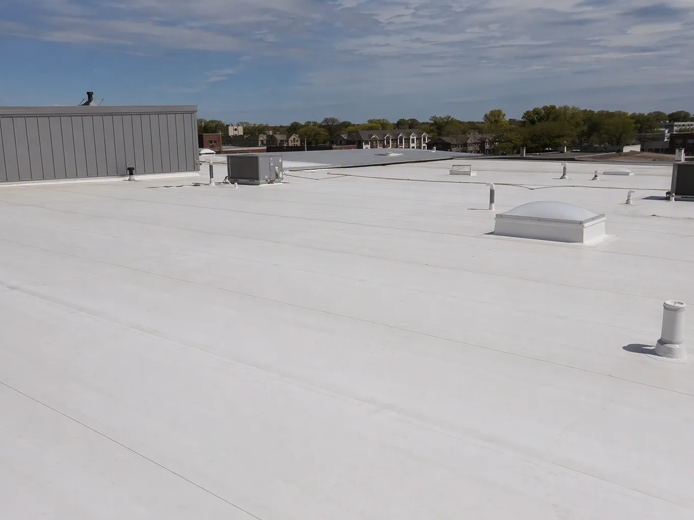 A roofer working on a residential pvc roofing job — mid-task, hands, tools and the work itself in sharp focus, the rest of the space softly out of focus