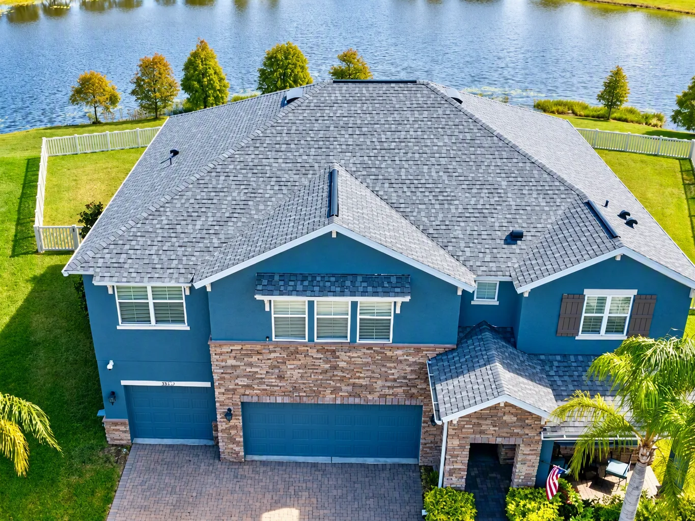 A roofer working on a residential roof replacement job — mid-task, hands, tools and the work itself in sharp focus, the rest of the space softly out of focus