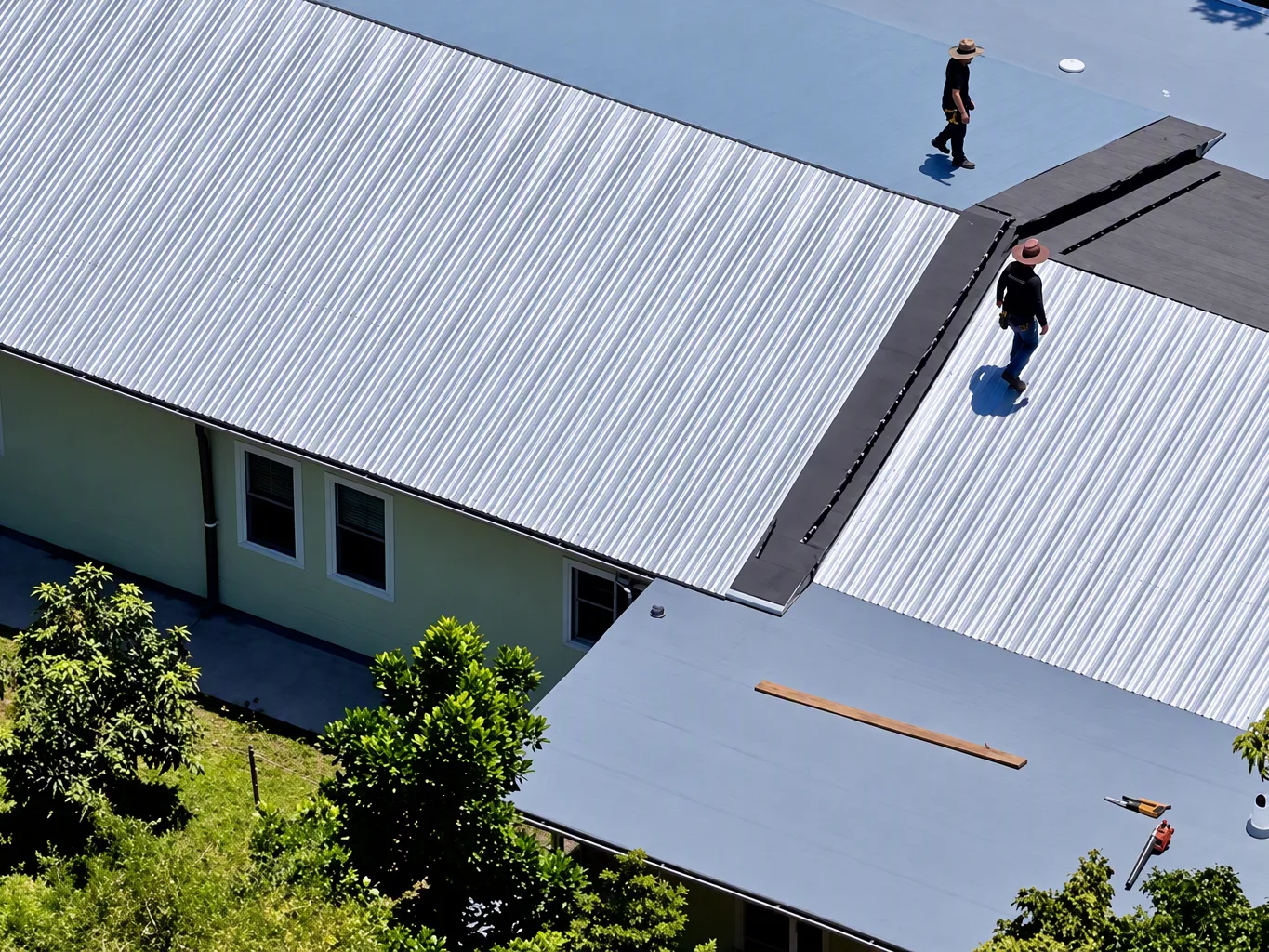 A roofer working on a residential emergency roof repair job — mid-task, hands, tools and the work itself in sharp focus, the rest of the space softly out of focus