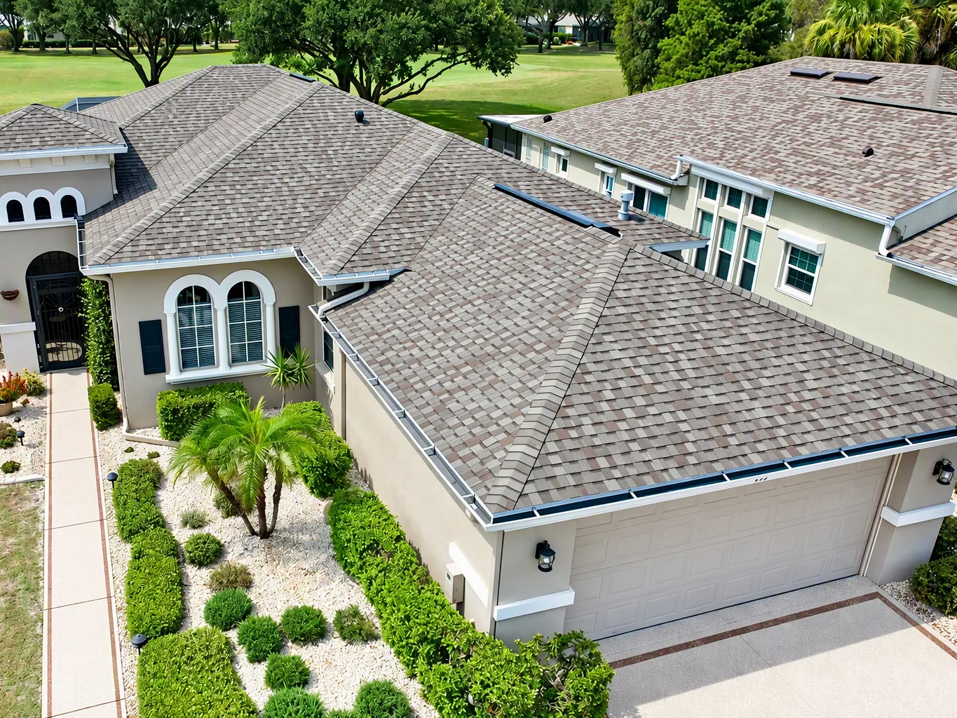 A roofer working on a residential shingle roofing job — mid-task, hands, tools and the work itself in sharp focus, the rest of the space softly out of focus